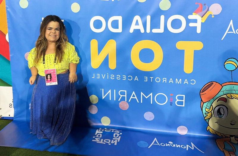 Rebeca Costa standing in front of a banner at Carnival